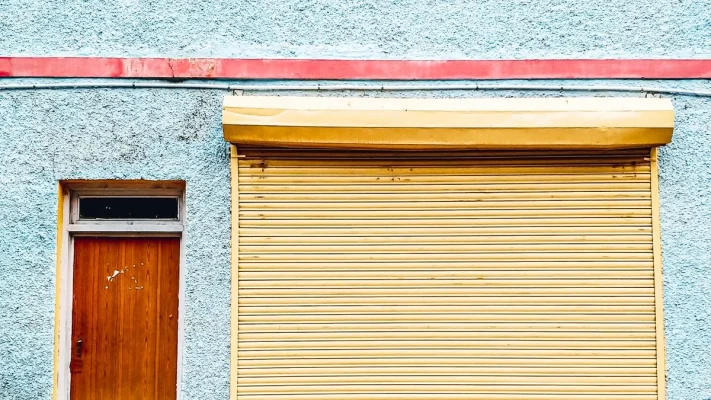Minh hoạ cửa cuốn màu vàng cạnh cửa đi bằng gỗ